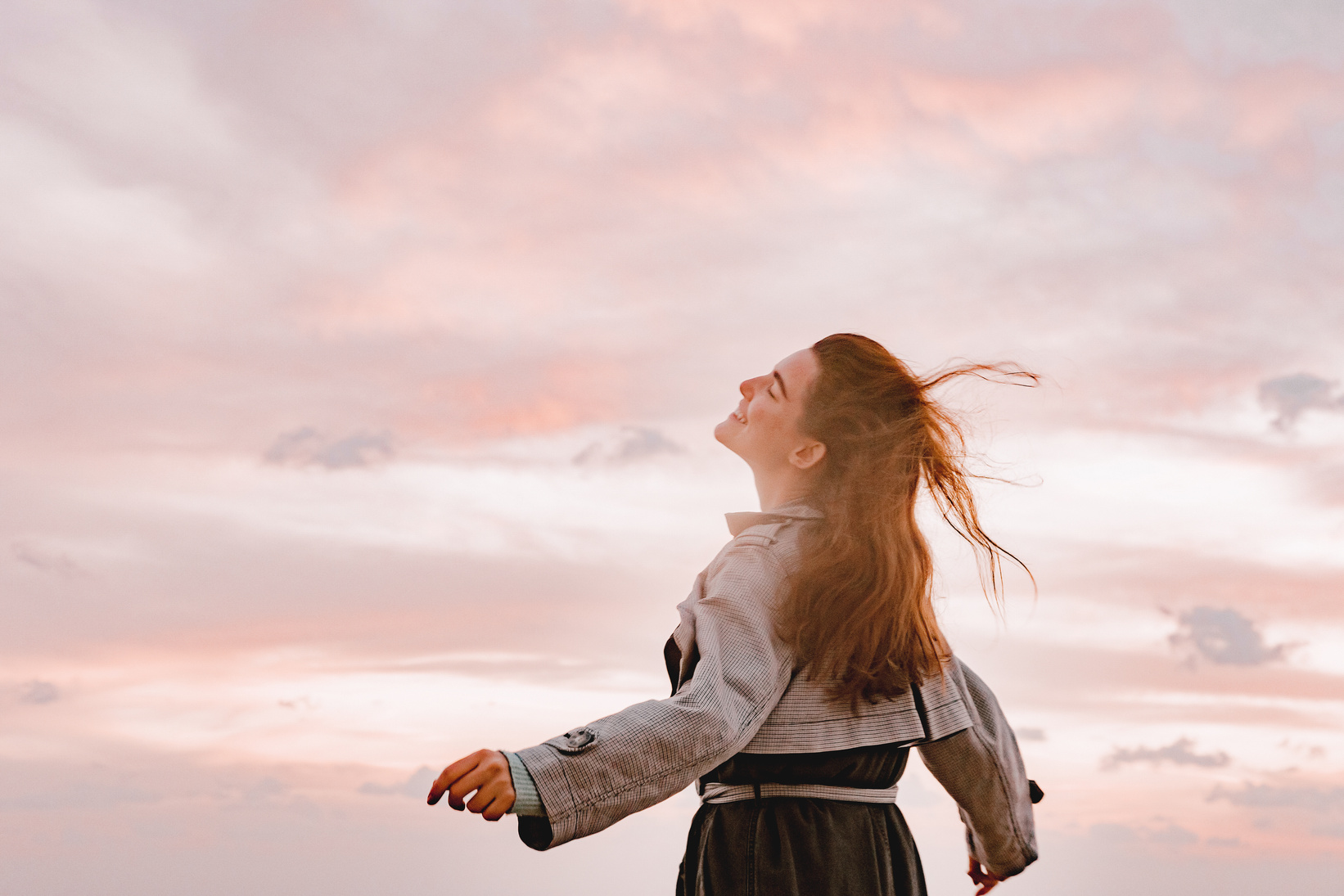 Happy Woman Smiling, Spreading Her Arms and Facing the Sky 